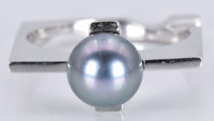 An 18ct white gold ring set with a grey pearl, 6.8g, size O
