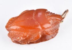 A carved amber pendant in the form of a beetle, 1 x 3cm