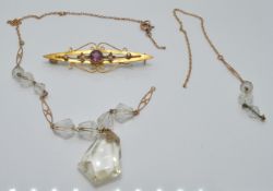 A 9ct gold necklace (1g) and a 9ct gold brooch set with amethyst and seed pearls (1.9g)
