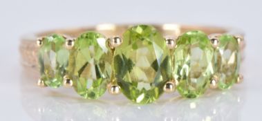 A 9ct ring set with five oval cut peridot, 3.1g, size O