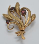 A 9ct gold brooch set with garnets in a bouquet design, 9.7g