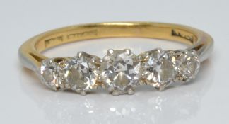 An 18ct gold ring set with five diamonds, the centre stone approximately 0.25ct, 2.6g, size L