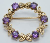 A 9ct gold brooch set with amethysts and butterfly design, diameter 3cm, 5.2g