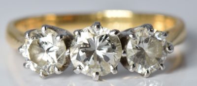 An 18ct gold ring set with three diamonds, the largest diamond approximately 0.5ct, the others