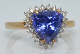 A 9ct gold ring set with a trillion cut tanzanite surrounded by diamonds, 3.2g, size O