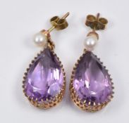 A pair of earrings each set with a pear cut amethyst and a pearl to the stud, 0.5 x 2cm