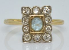 An 18ct gold ring set with an oval cut aquamarine surrounded by diamonds, 2.2g, size L