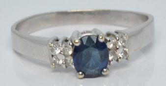 A white gold ring set with an oval cut sapphire and four diamonds to each shoulder, 3.4g, size R/S