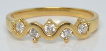 An 18ct gold ring set with five diamonds in a stylised wave setting, 2.7g, size N/O