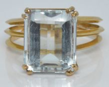 An 18ct gold ring set with an emerald cut aquamarine, 3.9g, size M