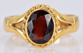A 22ct gold ring set with an oval garnet, 7.0g, size O