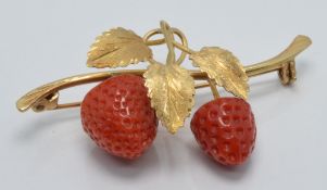 An 18k gold brooch set with two coral drops in the form of a strawberry plant, 2.6 x 4.5cm, 6.6g