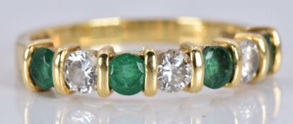 An 18ct gold ring set with alternating emeralds and diamonds, each gemstone approximately 0.15ct,
