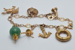 A 9ct gold charm bracelet with seven 9ct gold charms including a horse shoe and horse, anchor,