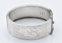 A hallmarked silver bangle with engraved bird and foliate decoration, Birmingham 1935, 33g