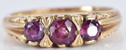 A 9ct gold ring set with three round cut garnets, 3.1g, size M