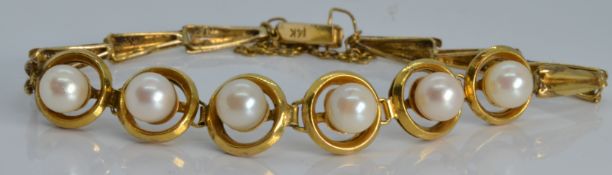 A 14k gold bracelet set with pearls in halos