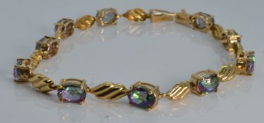 A 9ct gold tennis bracelet set with mystic topaz