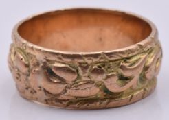 A yellow metal ring with embossed decoration, 3.8g, size G/H