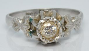 An 18ct white gold ring set with a round cut diamond of approximately 0.25ct in a raised platinum