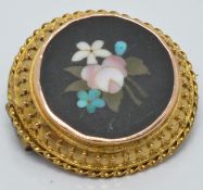 A c1900 Victorian yellow metal brooch set with a pietra dura plaque, diameter 2.4cm