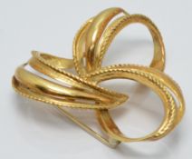 An 18k gold brooch in a stylised floral design, diameter 4cm, 8.4g