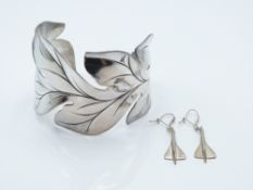A white bangle in a foliate design (63g) and a pair of Concorde earrings