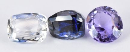 A loose purple sapphire and two blue sapphires