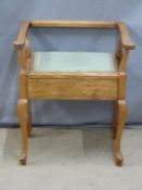 An upholstered mahogany piano stool