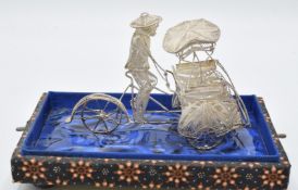 A silver filigree rickshaw with rider, marked to rear 925, length 10cm, in glass case