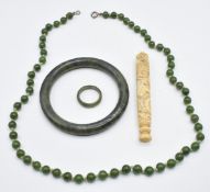 A nephrite jade bangle, necklace and ring together with a carved Chinese bone needle case