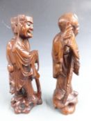 A pair of Chinese carved hardwood figures with bone teeth, H30cm