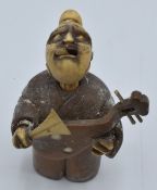 Chinese sandalwood and ivory netsuke depicting a man playing a lute with moving tongue, 7cm