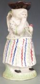An 18th/19thC Prattware Toby jug of an old woman taking snuff
