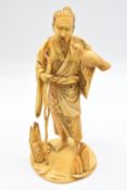 A 19thC Japanese Meiji period signed ivory okimono of a bearded man with gnarled staff and bird on