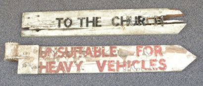 Two traditional English wooden crossroads signs 'To the church' and 'Unsuitable for heavy