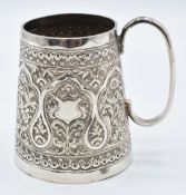 Indian white metal tankard with repoussé decoration and vacant cartouche, H8cm, 131g