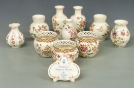 Ten Zsolnay Pecs vases including three with reticulated rims and an advertising plaque, tallest 16cm