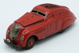 Schuco Kommando 2000 clockwork tinplate model car with red body and hubs.
