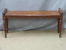 A 19thC (probably late Georgian) mahogany window seat with turned rests, raised on slim stepped