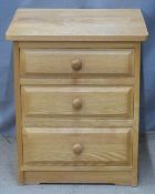 A contemporary light oak bedside chest of three graduated drawers and a dressing table mirror, W49 x