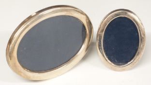 Two modern oval hallmarked silver photograph frames with easel backs, maximum diameter of larger