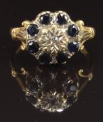 An 18ct gold ring set with a diamond surrounded by sapphires, size P, 5.1g