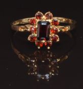 A 9ct gold ring set with garnets, size R, 1.7g