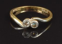An 18ct gold ring set with two diamonds in a twist setting, size O, 2.1g