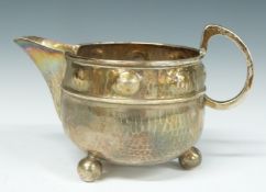 A E Jones Arts & Crafts jug with hammered and embossed decoration, Birmingham 1924, length 13cm,