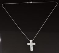 An 18ct white gold cross set with a princess cut diamond, baguette cut diamonds and round cut