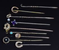 Two Edwardian 9ct gold stick pins in the form of horseshoes, a Victorian 9ct gold stick pin set with