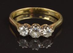 An 18ct gold ring set with three diamonds, the centre stone approximately 0.25ct, size P, 2.9g