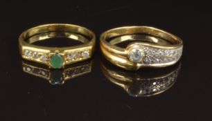 Two yellow metal rings, one set with an emerald and cubic zirconia, the other cubic zirconia, size T